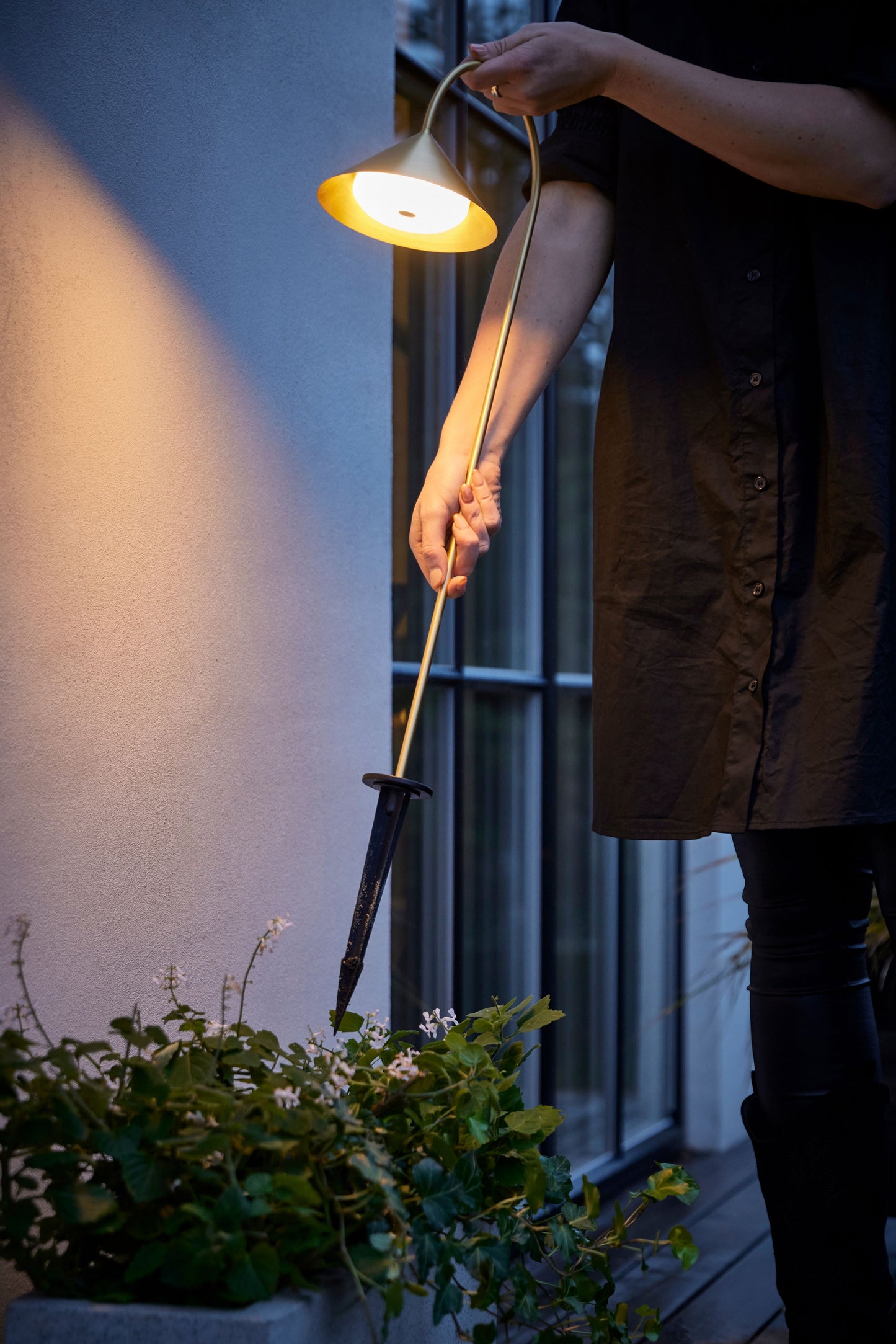 Grasp spyd lampe i messing i blomsterbed