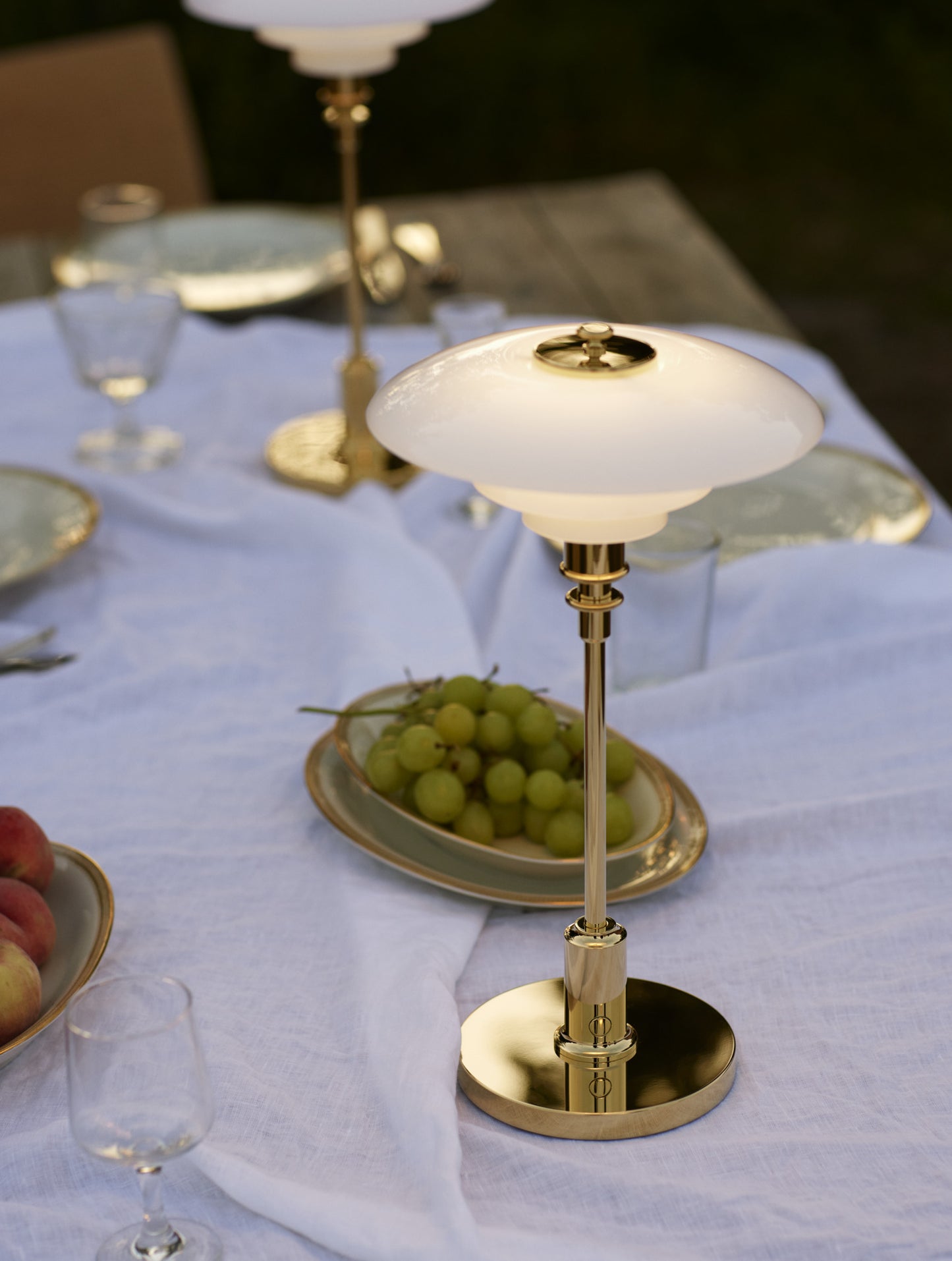 Louis poulsen ph 2/1 bordlampe i brass som står udenfor på et bord